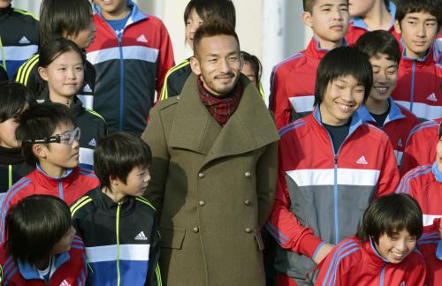 寄贈した練習用ジャージーを着る子どもたちと記念写真に納まる中田英寿さん