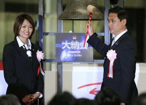 東京証券取引所の大納会で、鐘を鳴らす前にポーズをとる「なでしこジャパン」の安藤梢（左）と佐々木則夫監督