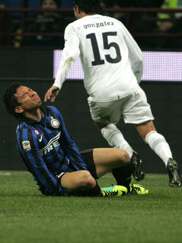 ラッツィオのMFゴンザレス（右）の蹴りを右足首にうけ、痛がるインテル・ミラノの長友