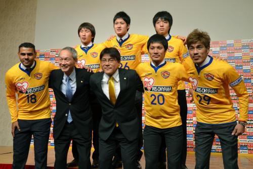 記念写真に納まるＪ１仙台の手倉森監督（前列中央）と新加入選手ら