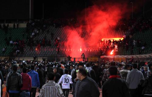 エジプトのサッカー場で起きた暴動で、発煙筒の火と煙が立ち上るスタンド