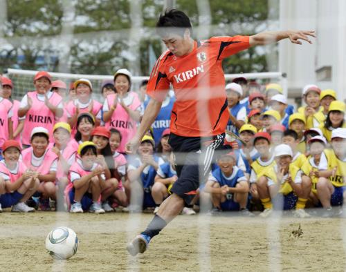 小学生の前で豪快にシュートを放つ、サッカー日本代表の香川真司