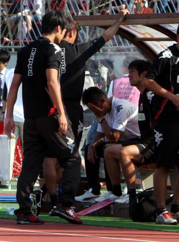 ＜札幌・新潟＞試合後、チームスタッフを前に顔を覆った札幌・石崎監督（中央）