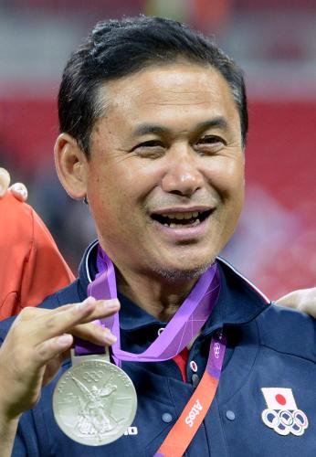 選手が獲得した銀メダルを手に笑顔の佐々木監督