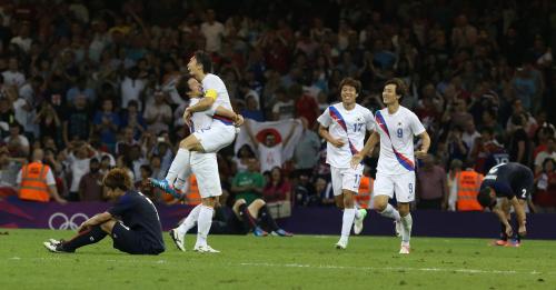 ＜日本・韓国＞試合終了後、喜ぶ韓国イレブン。左はガックリ座り込む大津