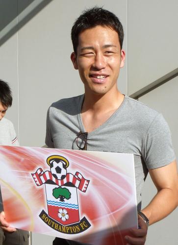 イングランド・プレミアリーグのサウサンプトン移籍が決まり、チームロゴを手に笑顔を見せる吉田