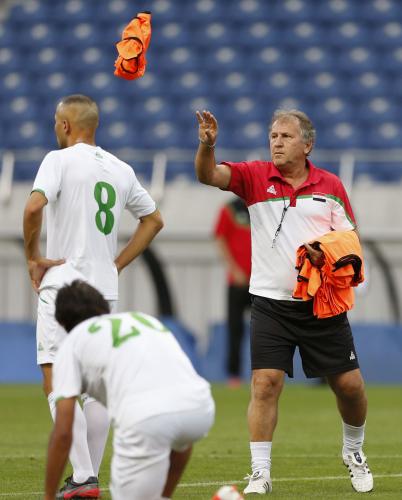 公式練習で選手にビブスを渡すイラクのジーコ監督（右）
