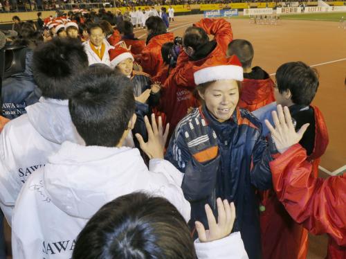 慈善試合終了後、被災地から招待された子どもたちとタッチを交わす澤