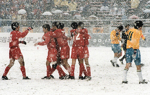 第７６回全国高校サッカー選手権大会決勝は雪の中で行われ、優勝し喜ぶ東福岡イレブン（左）と肩を落とす帝京イレブン