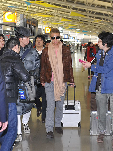 関西国際空港に到着し、報道陣に囲まれ構内を歩く本田圭佑