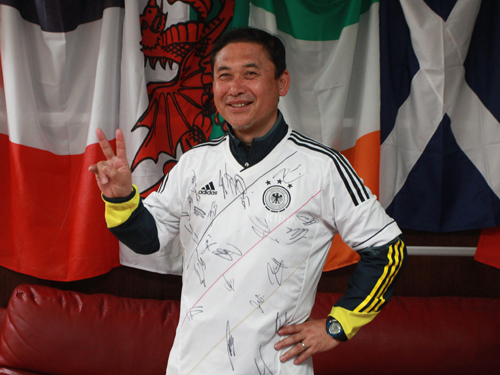 サッカー男子ドイツ代表のサイン入りユニホームを着る佐々木監督