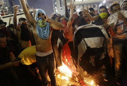18日、ブラジル・サンパウロの市役所前でサンパウロ州旗を燃やすデモ隊