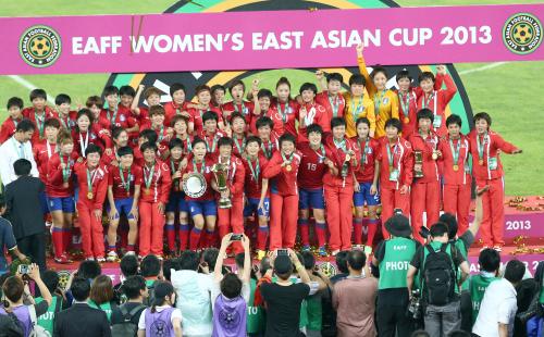 サッカー東アジア・カップ大会終了後の表彰式で、和気あいあいとした雰囲気で一緒に記念撮影する優勝した北朝鮮チームと３位の韓国チーム