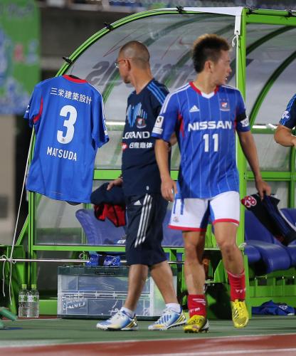 ＜湘南・横浜＞後半、交代した横浜・斎藤は松田直樹さんのユニホームを掲げたベンチの前を通り、引き揚げる