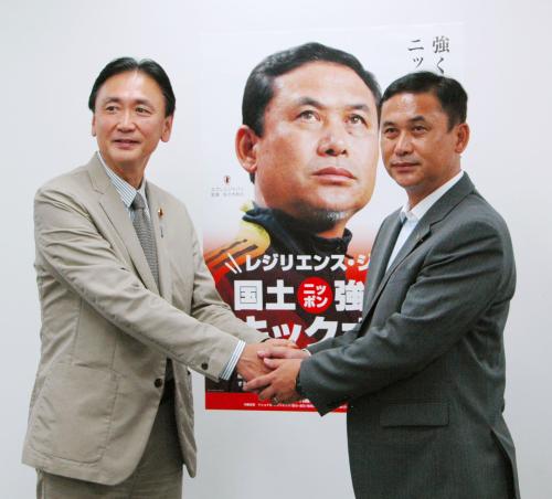 ポスターに起用され、古屋国土強靱化相（左）と握手するサッカー女子日本代表の佐々木則夫監督