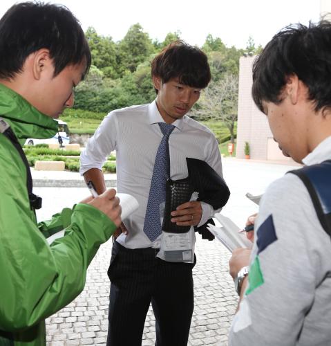 帰国後、記者の質問にこたえる日本代表ＤＦ森重（中央）