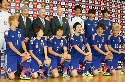 サッカーのＷ杯ブラジル大会で日本代表が着用する新ユニホーム姿で記念写真に納まる選手ら。女子の宮間（前列左から２人目）、フットサルの北原亘（前列左から４人目）もそれぞれの新ユニホームで加わった