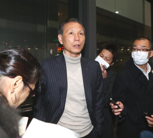 成田空港に到着した原技術委員長（中央）は報道陣の取材を受ける