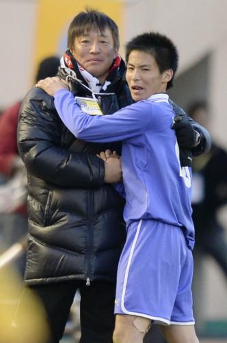 決勝の延長後半に交代し、富山第一の大塚一朗監督（左）と抱き合う息子の翔主将