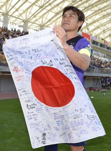 試合後にサポーターから応援メッセージの書かれた日の丸を受け取る、Ｗ杯代表の広島・青山