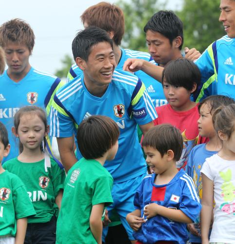 地元の子供たちとの記念撮影で、日本のユニホームを着た子に話し掛ける香川