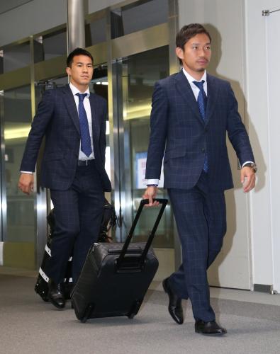 成田空港に到着した長友（右）と岡崎