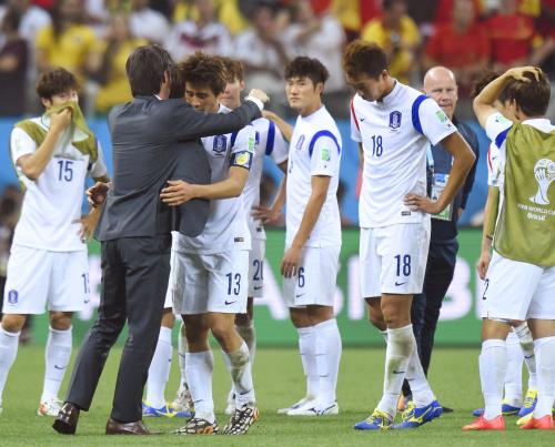 １次リーグ敗退が決まり、選手と抱き合う韓国の洪明甫監督