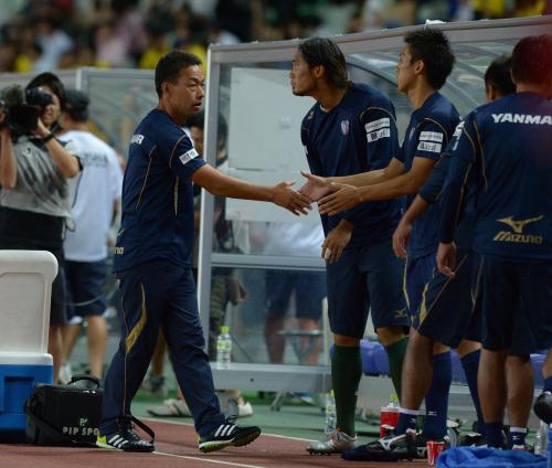 ＜Ｃ大阪・柏＞リーグ戦初勝利にイレブンと握手するＣ大阪・大熊監督（左）