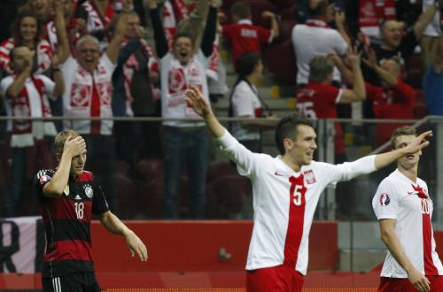 歴史的勝利を喜ぶポーランドの選手と、頭を抱えるドイツのクロース（左）（ＡＰ）