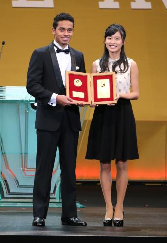 ベストヤングプレーヤー賞に選ばれ、プレゼンターの小島瑠璃子（右）と記念撮影する鹿島・カイオ