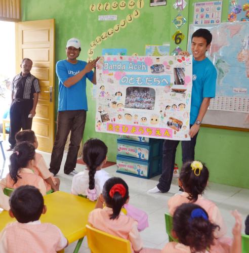 インドネシアの幼稚園で、東日本大震災被災地の子どもたちが書いた寄せ書きを見せるフランクフルトの日本代表ＭＦ長谷部（右）