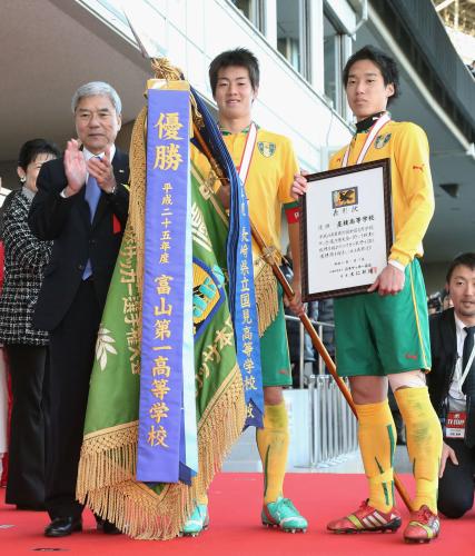 日本サッカー協会の大仁邦弥会長（左）から優勝旗と表彰状を贈られた星稜・鈴木（中央）と平田
