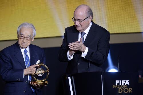 国際サッカー連盟会長賞を受賞した、90歳にして第一線で取材を続けるサッカージャーナリストの賀川浩さん。右はブラッター会長（ＡＰ）