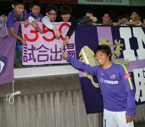 ＜横浜・広島＞３５０試合出場を祝う横断幕を掲げるサポーターの横で笑顔の広島・佐藤