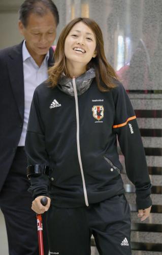つえをつきながら笑顔で出発口に向かうサッカー女子日本代表の安藤