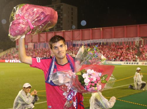 ＜Ｃ大阪・大分＞この試合を最後にスペインリーグに挑戦する長谷川は、サポーターから受け取った花束を手にサポーターの声援に応える