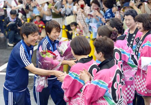カナダから帰国し、地元の人たちから祝福されるサッカー女子日本代表の福元美穂（左）、宮間あや