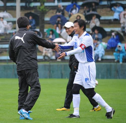 ＜磐田・ＪＦＬアスルクラロ沼津＞試合終了後、磐田の名波監督（左）と握手する中山（右）。奥は磐田の鈴木ヘッドコーチ