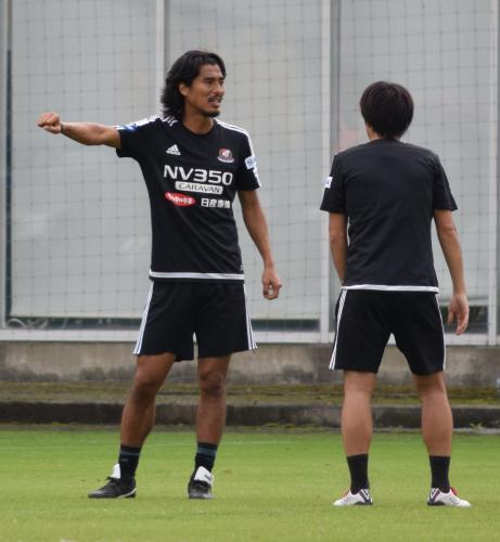 練習中、選手と話し合う中沢（左）