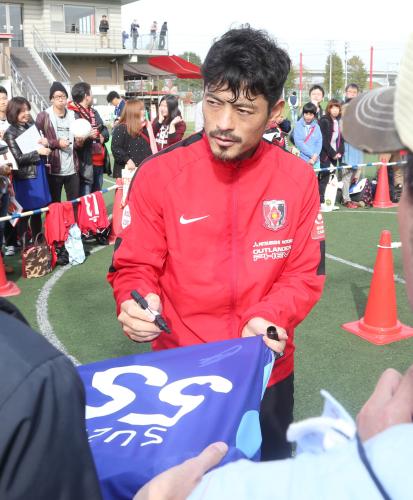 ファンサービスデーで代表時代の背番「５５」にサインする浦和ＭＦ鈴木