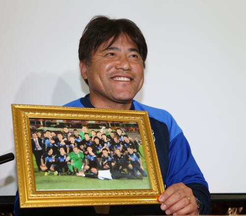 リオ五輪出場を決めた写真を手に笑顔を見せるＵ―２３日本代表の手倉森監督