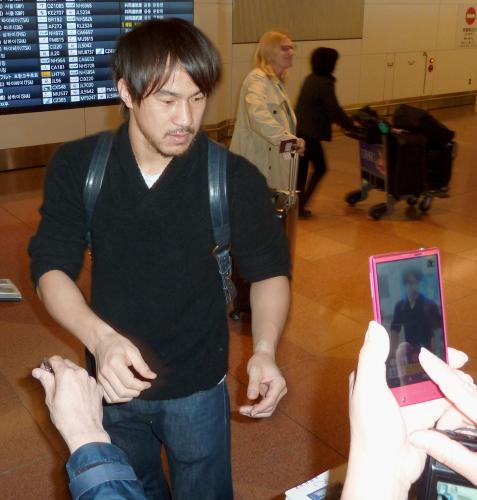帰国し、ファンにサインをするサッカー日本代表の岡崎慎司