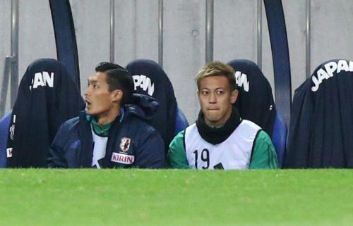 槙野（左）とともにベンチに座って試合を見る本田