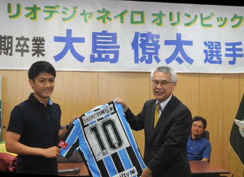 母校・静岡学園の石田校長にサイン入りユニホームを手渡しし笑顔の大島（左）。右後方は川口監督