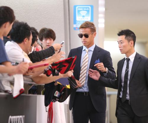 成田空港に到着した本田（右から２人目）はファンサービスを行う