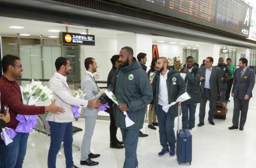 成田空港到着ゲートで在日留学生から“勝利”を意味する白いバラを渡されるサウジアラビア代表選手ら