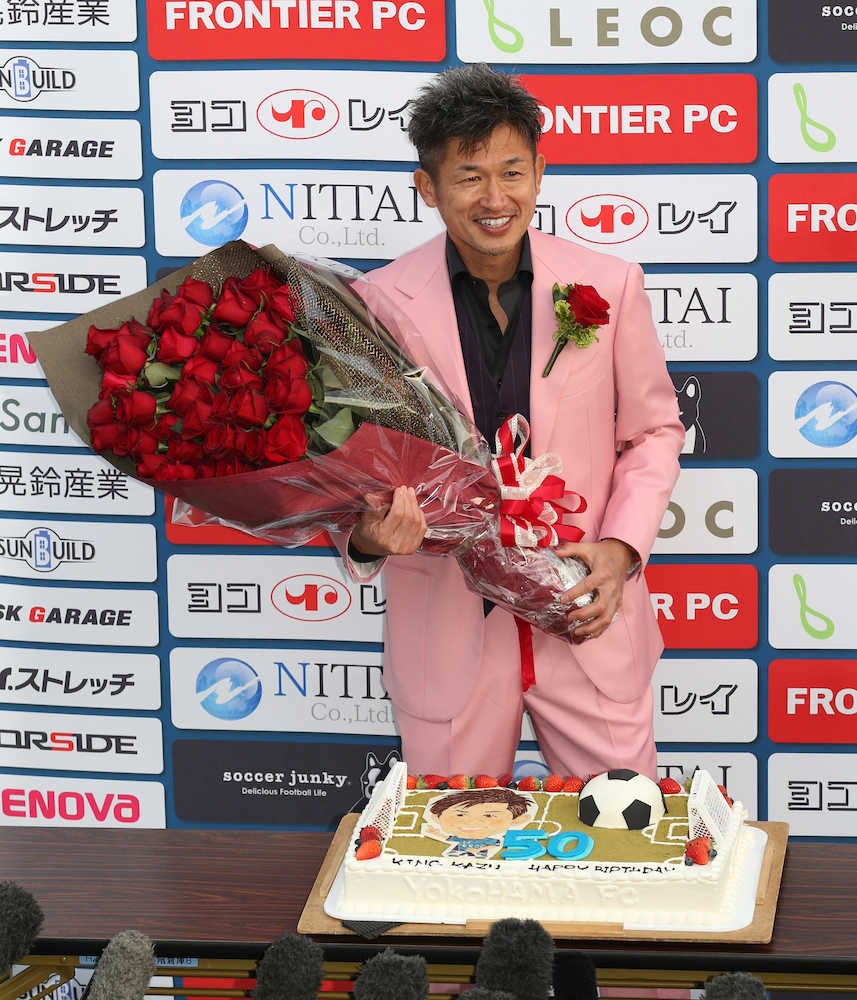 ＜横浜ＦＣ・松本＞ピンク色のスーツを着た横浜ＦＣ・三浦はケーキの前でバラを手に笑顔
