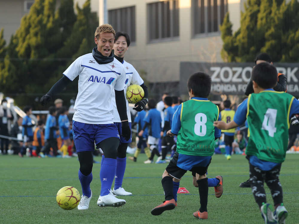 サッカークリニックでチビっ子たち相手に本気の動きを見せる本田（左）