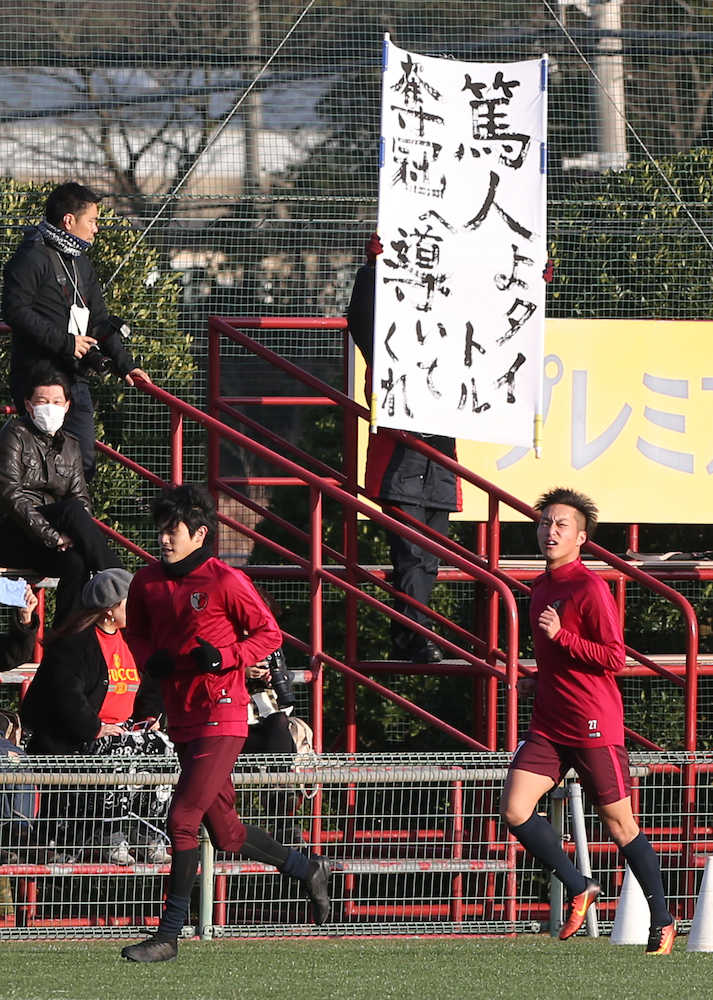 らしく復帰！横断幕を掲げるサポーターの前を笑顔でランニングする鹿島ＤＦ内田（左）