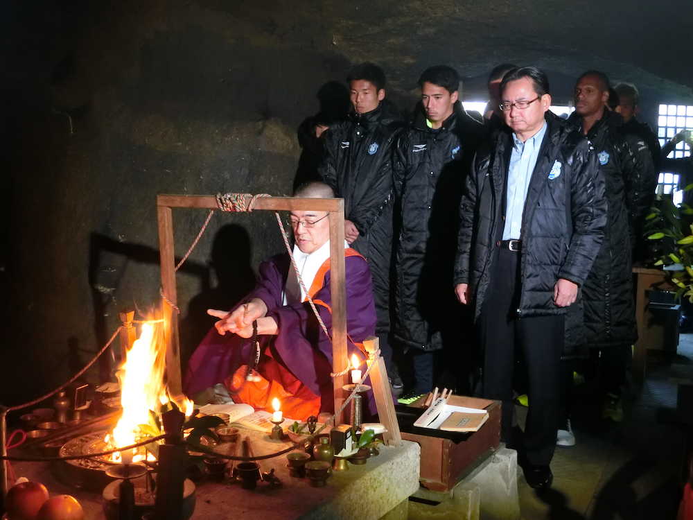 妙円寺の洞窟内で参拝する湘南の真壁会長（右）と菊地主将（中央）